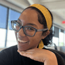 Ari Ross - Chinese-African American woman wearing black-rimmed glasses, big smile, and holding hand under face Ari Ross - Chinese-African American woman wearing black-rimmed glasses, big smile, and holding hand under face